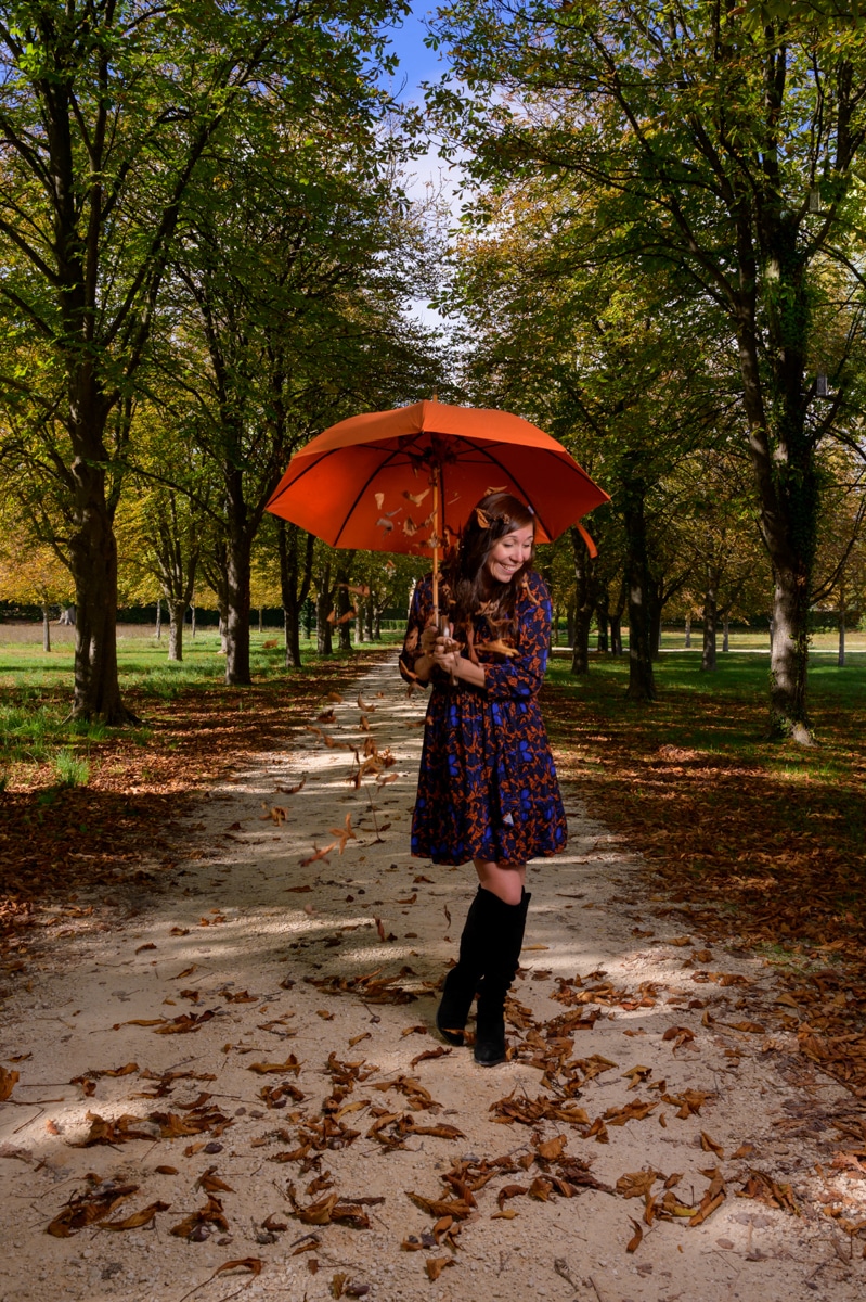 une jeune femme sous un parapluie d'automne