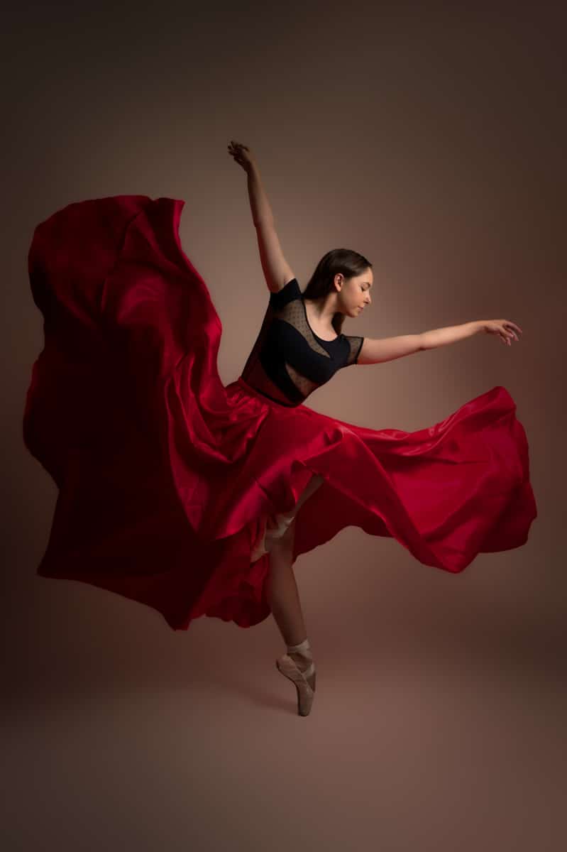 une danseuse classique avec un grand voile rouge