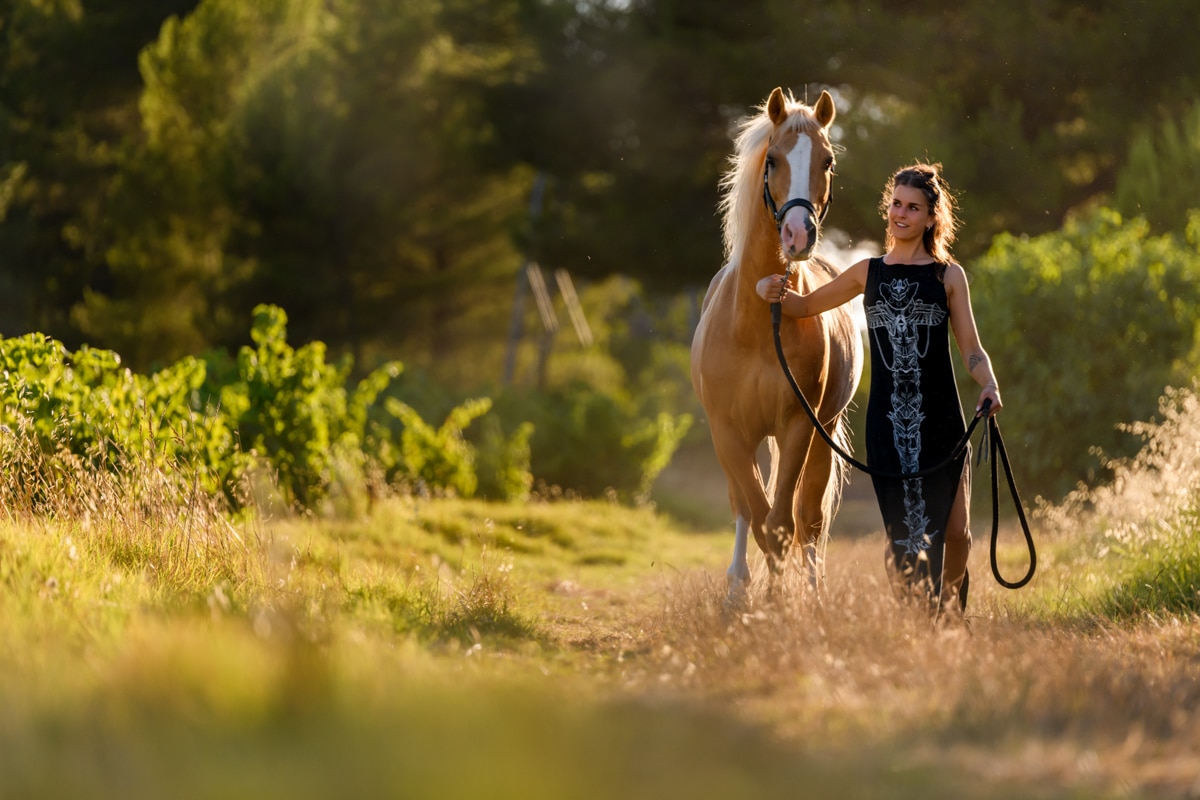 une femme marchant à côté de son cheval