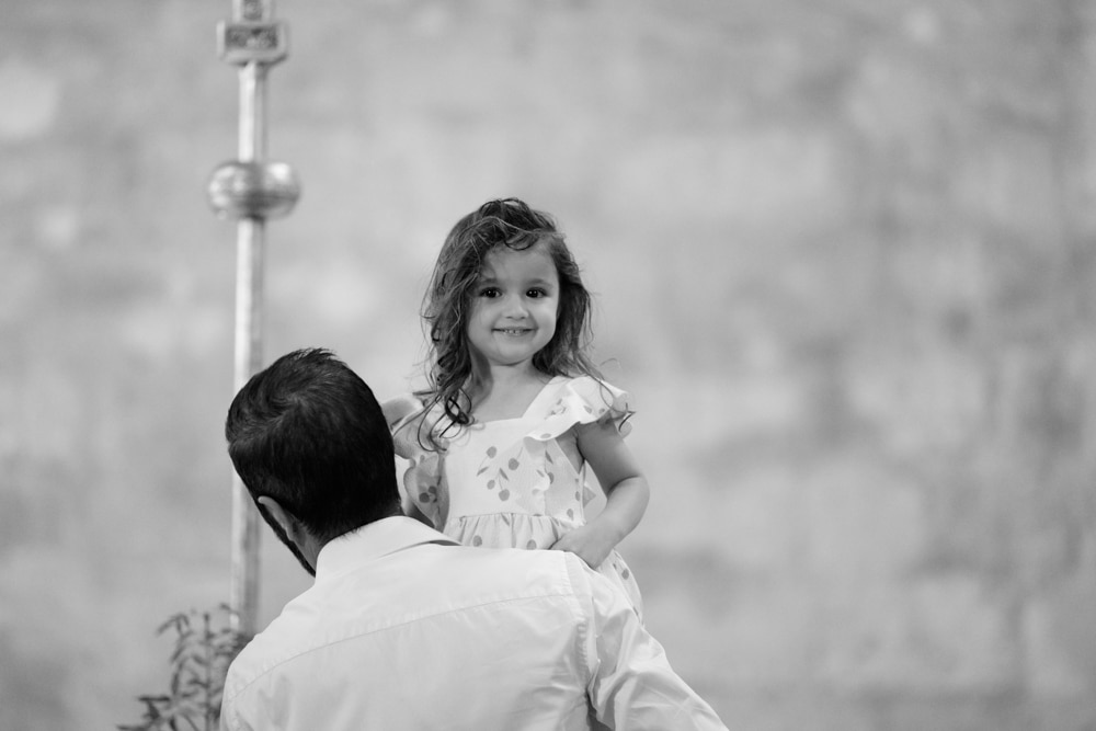 enfant dans les bras de son papa lors de son baptême à l'église