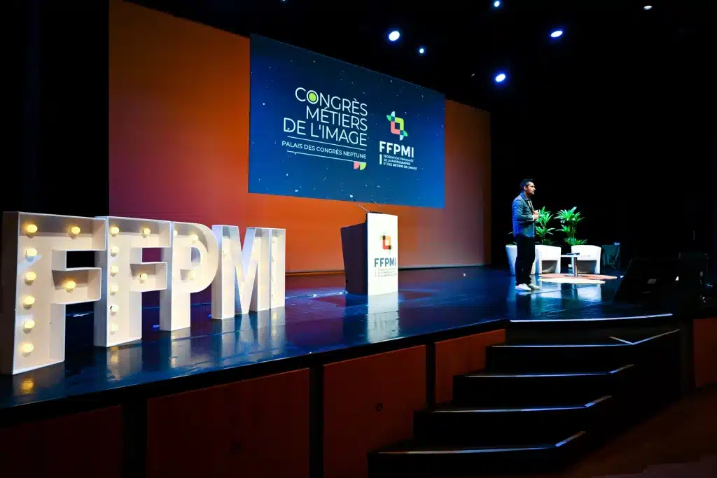 Scène du congrès FFPMI avec lettres géantes et pupitre – photo de Caroline Martens