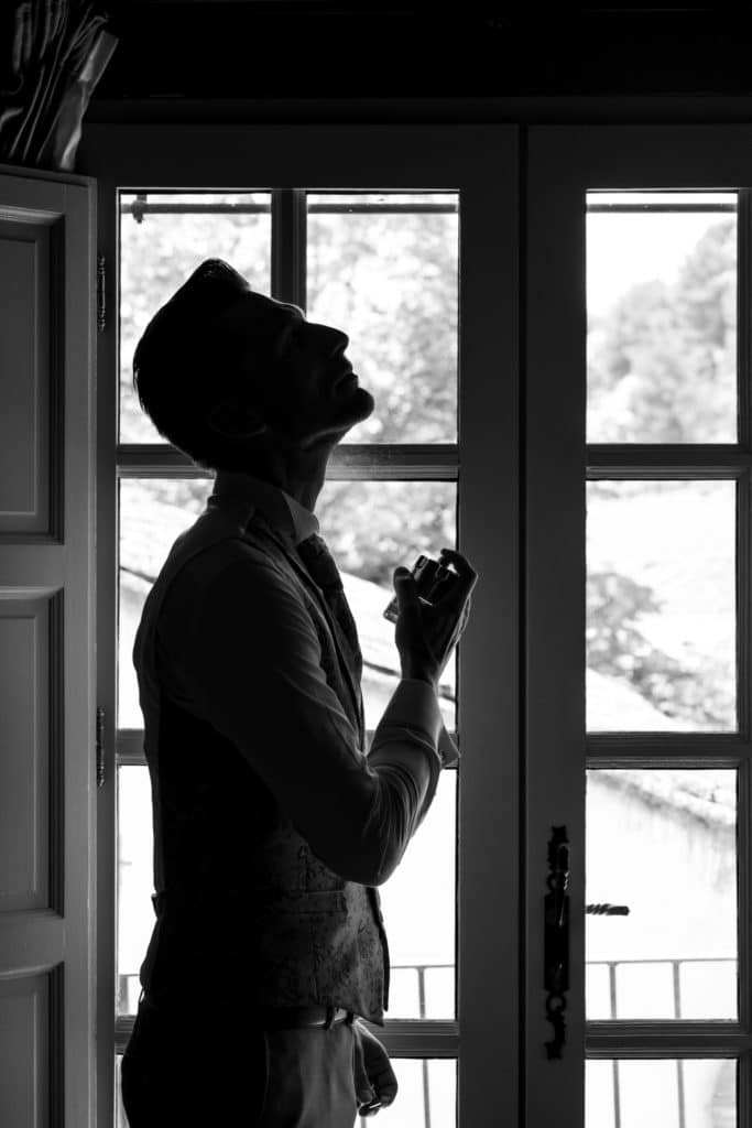 Portrait en contre-jour du marié pendant les préparatifs, ambiance intimiste et sobre