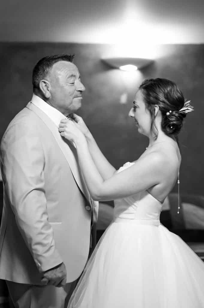 Moment d’émotion entre un père et sa fille avant la cérémonie de mariage, regards complices